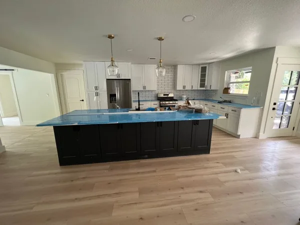 white kitchen island with a blue quartz countertop by WoodArt Cabinets San Antonio