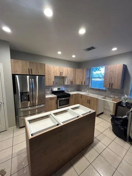 white and gray kitchen with island and stainless fridge by WoodArt Cabinets San Antonio