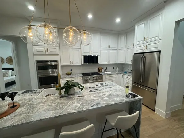 White kitchen with granite waterfall island by WoodArt Cabinets San Antonio