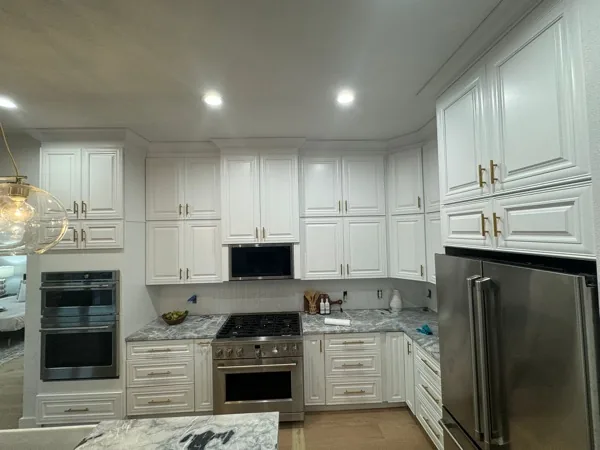 white kitchen with a stainless refrigerator by WoodArt Cabinets San Antonio