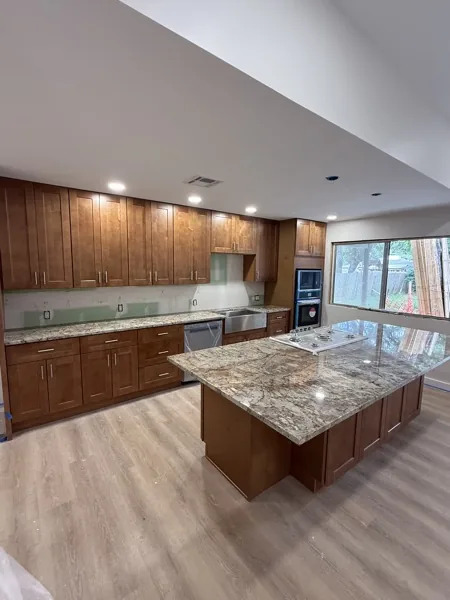 Maple kitchen with granite island in Stone Oak by WoodArt Cabinets